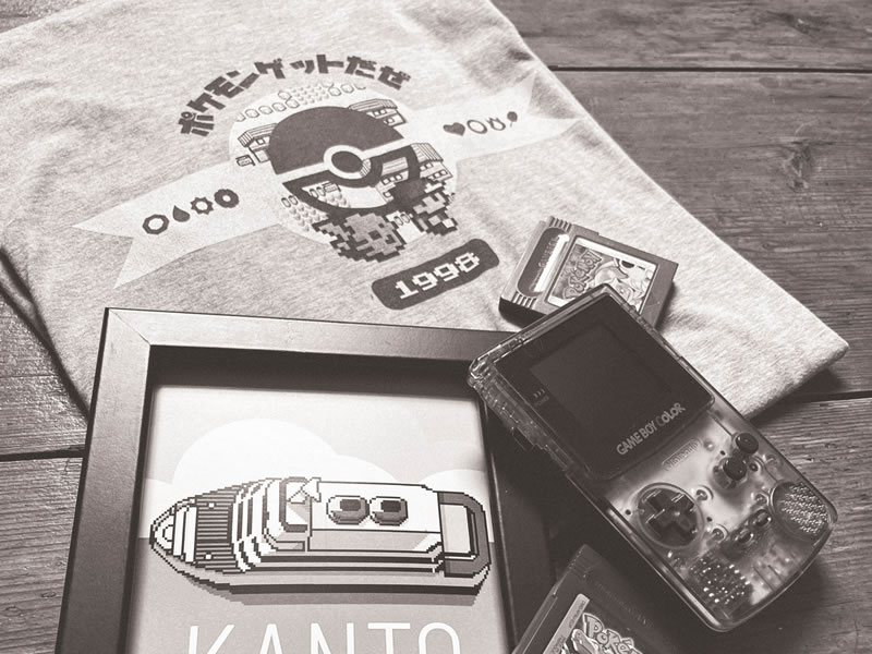 Image of a classic Pokemon t-shirt and Nintendo gameboy. black and white
